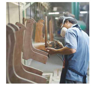 Image of Worker painting wooden furniture